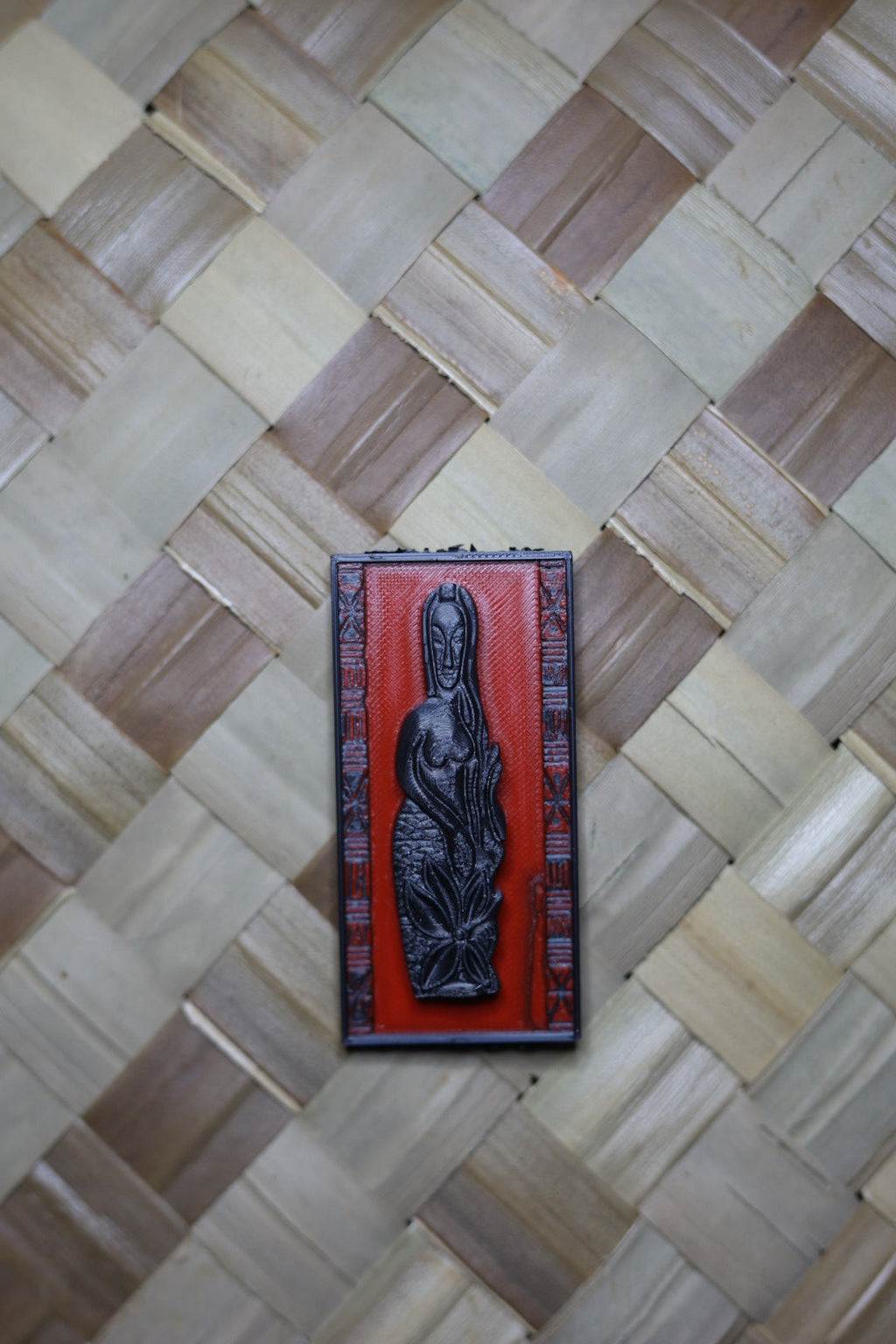 Decorative wooden box with a figurine on a woven mat background