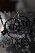 Black necklace with circular pendant on a decorative card