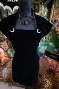 Black dress on a mannequin with jewelry against a colorful background